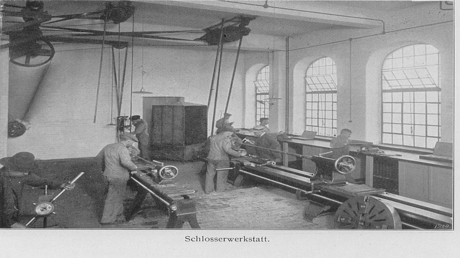 Schwarz-Weiß-Foto: Raum mit Männern bei der Arbeit in der Schlosserei